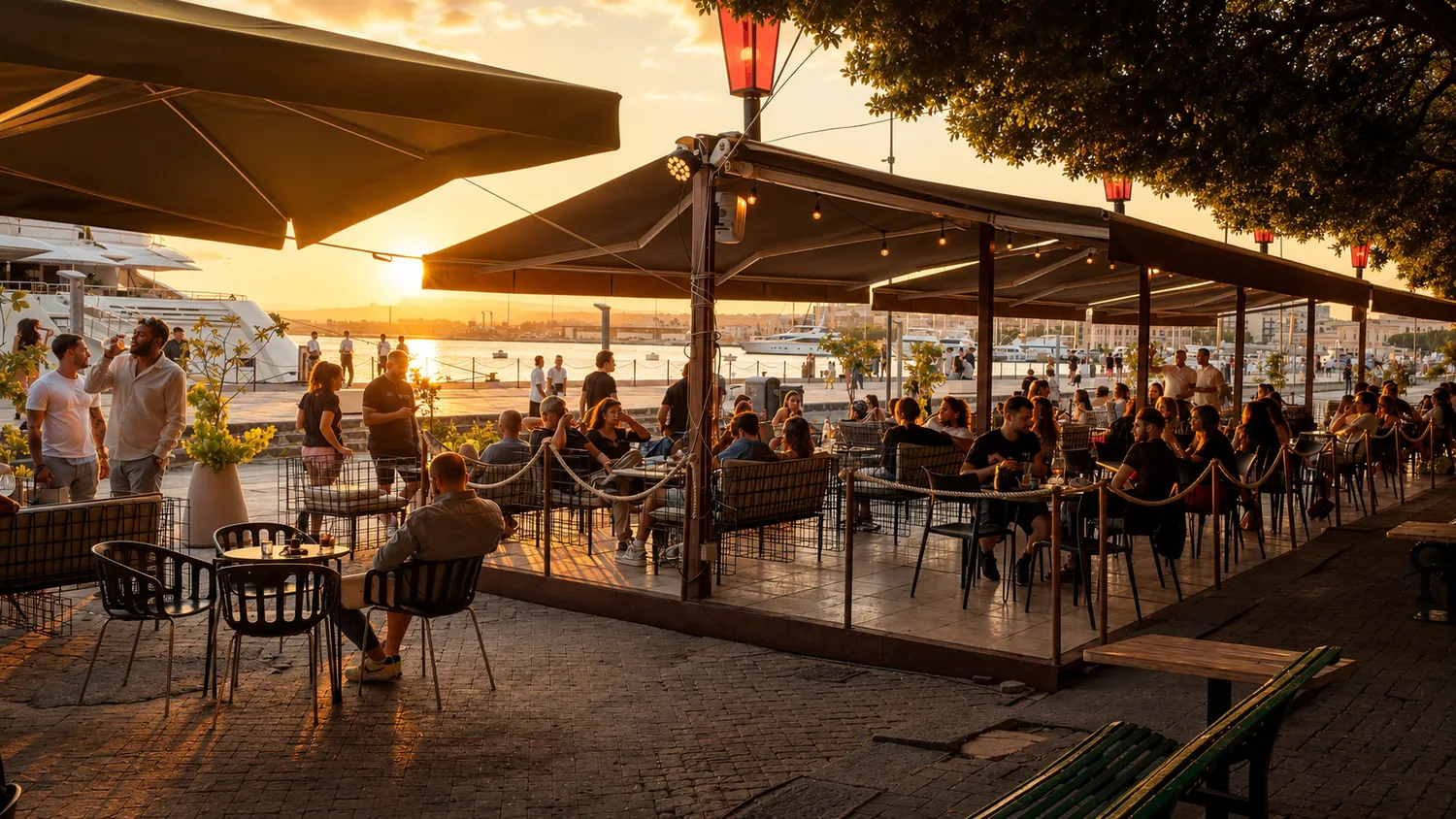 The harbour-side terrace at Fratelli Burgio filled with diners at sunset.