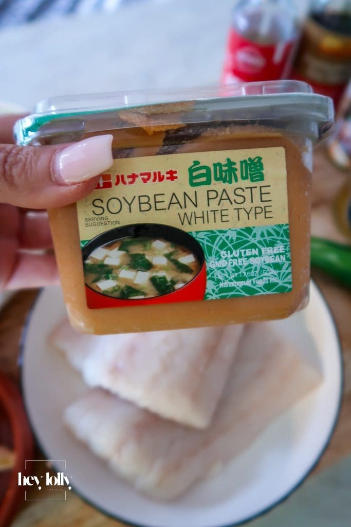 Raw cod fillets with miso butter ingredients on a board